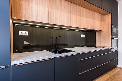 Centrální varná deska a černý granitový dřez v kuchyni na míru od Glanc Kuchyně.