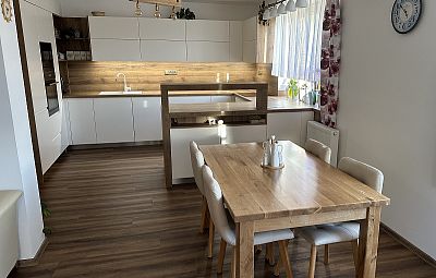 Glanc Kuchyně - Moderní vanilková kuchyně s barovým pultem, kuchyně na míru, dřevěný obklad kuchyně 