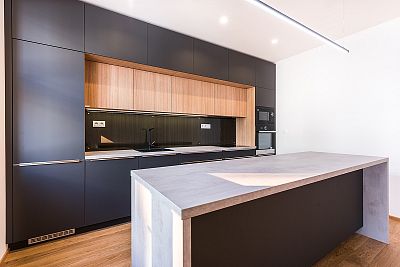 Kontrast matné černé a světlého dřeva v kuchyni na míru od Glanc Kuchyně.
