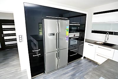 Luxusní funkčnost: Vysoký blok s americkou lednicí Beko v kuchyni od Glanc Kuchyně.