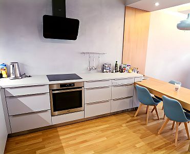 Příroda se setkává s moderní: Kombinace dubového dekoru a modrých židlí v kuchyni od Glanc Kuchyně.