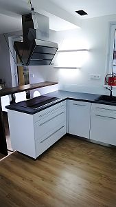 Výhodně umístěná varná deska a designová digestoř v kuchyni na míru od Glanc Kuchyně