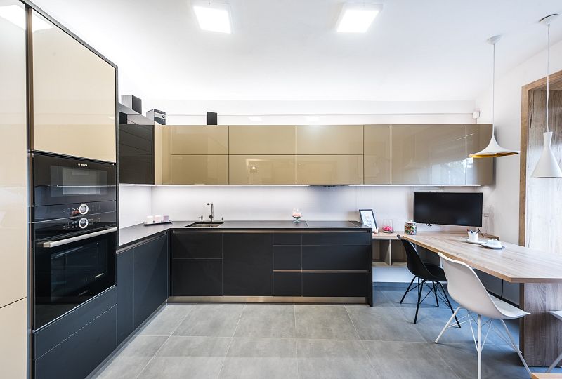 Moderní kuchyň ve tvaru "L" s inovativními prvky a elegantním propojením s jídelnou